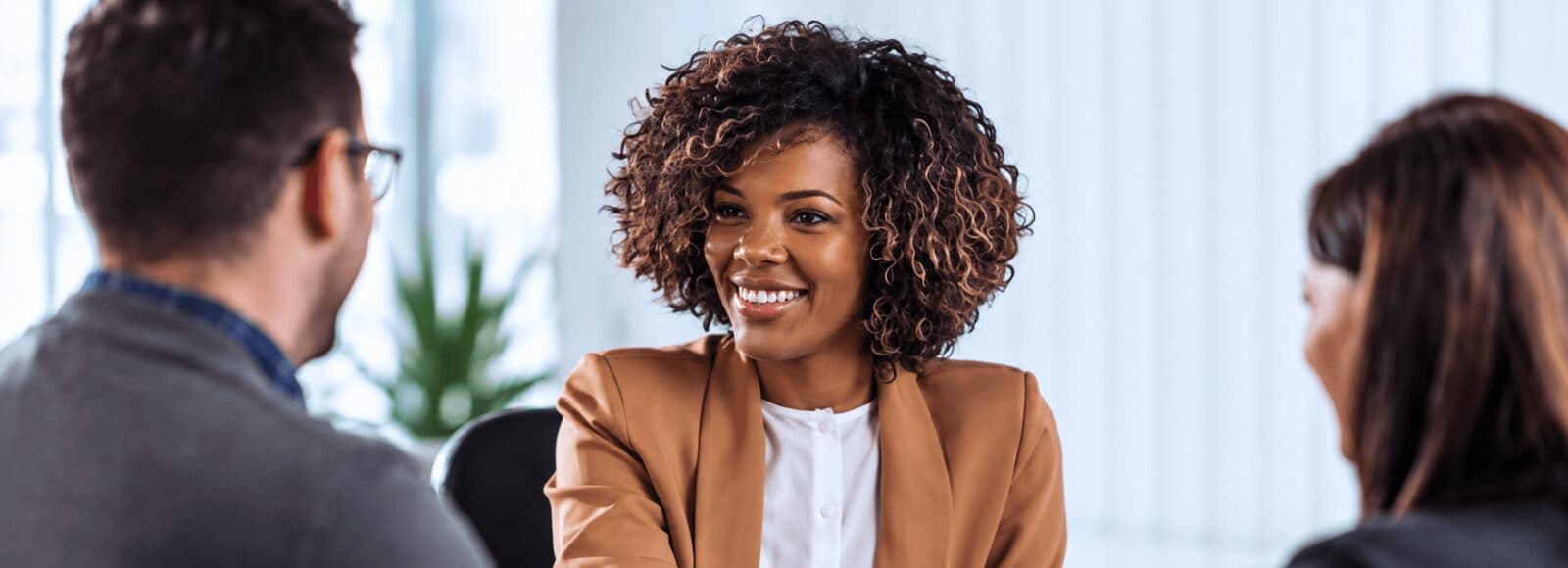 A founder smiling while answering questions across a table